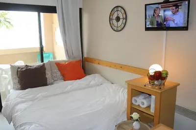 a bedroom with a bed and a clock on the wall at Appartement Palm d'Azur in Cannes