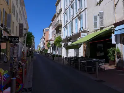 an empty street with tables and chairs and buildings at 1 Bedroom Notre Dame 2 mins from the Croisette and the Palais 225 in Cannes