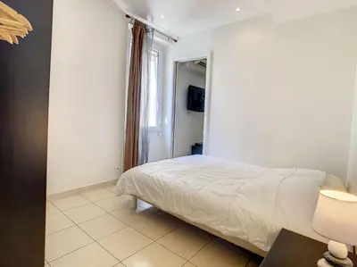 a small bedroom with a bed and a window at 1 Bedroom Notre Dame 2 mins from the Croisette and the Palais 225 in Cannes