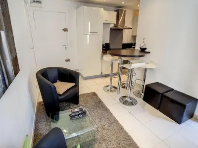 a living room with a chair and a table at 1 Bedroom Notre Dame 2 mins from the Croisette and the Palais 225 in Cannes