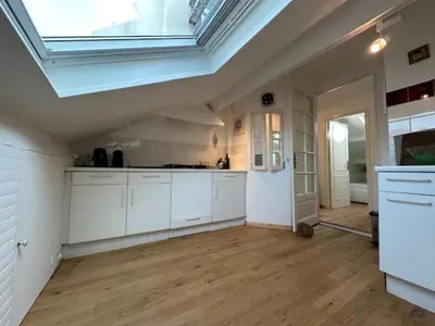 a large kitchen with white cabinets and a skylight at Chez Nella in Cannes