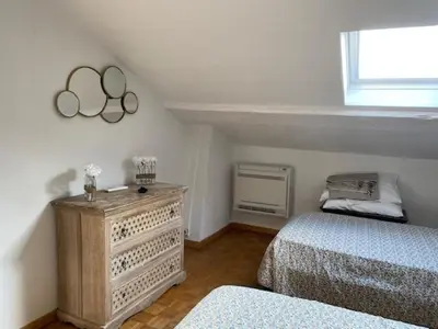 a bedroom with two beds and a dresser and a window at Chez Nella in Cannes