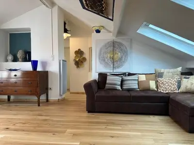a living room with a brown couch and a wooden floor at Chez Nella in Cannes