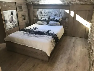 a bedroom with a bed with a painting on the wall at Love Room Jacuzzi Croisette in Cannes