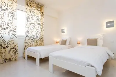 two beds in a white room with a window at SEA VIEW 3 beds next to Palais in Cannes