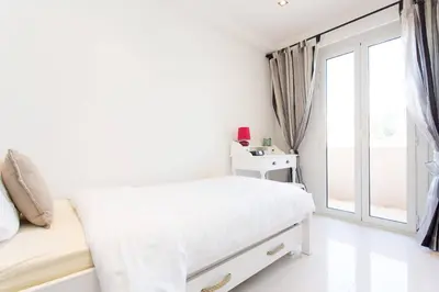 a white bedroom with a bed and a window at SEA VIEW 3 beds next to Palais in Cannes