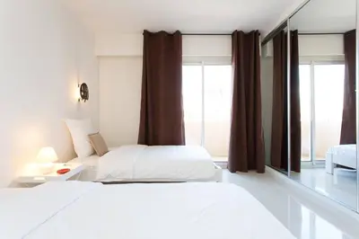 a bedroom with two beds and a mirror at SEA VIEW 3 beds next to Palais in Cannes