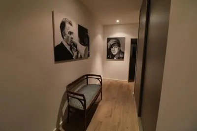 a hallway with a chair and pictures on the wall at Luxury, central 3 bedroom, 3 bathrooms 5 mins from the Palais 410 in Cannes
