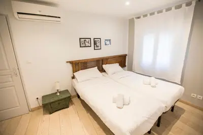 a bedroom with two beds with white sheets and towels at Résidence Bouttau by Connexion in Cannes