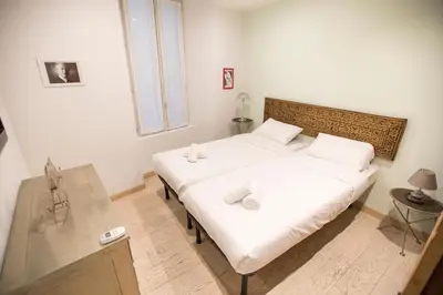 a bedroom with two beds with white sheets and a window at Résidence Bouttau by Connexion in Cannes