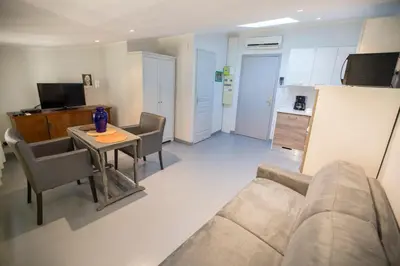 a living room with a couch and a table and a kitchen at Résidence Bouttau by Connexion in Cannes