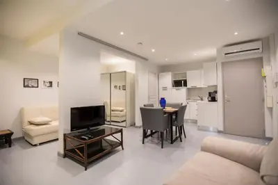 a living room with a couch and a table with a television at Résidence Bouttau by Connexion in Cannes