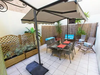a patio with an umbrella and a table and chairs at Studios Alea in Cannes