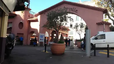 a pink building with an arch in a street at Studios Alea in Cannes