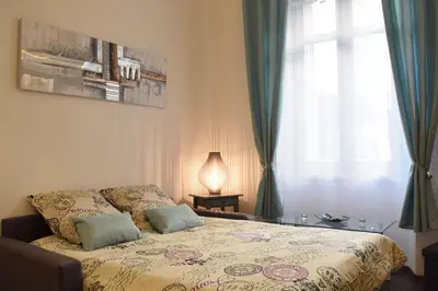 a bedroom with a bed with a table and a window at Coeur de Cannes - 5mn Croisette Palais - Terrasse et Parking in Cannes