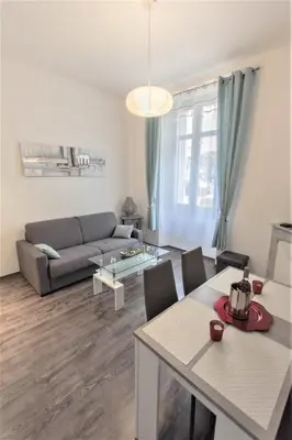 a living room with a couch and a table at Coeur de Cannes - 5mn Croisette Palais - Terrasse et Parking in Cannes