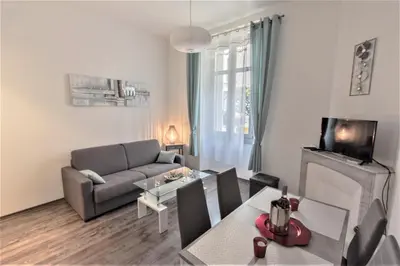 a living room with a couch and a table at Coeur de Cannes - 5mn Croisette Palais - Terrasse et Parking in Cannes