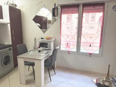 a kitchen with a table with chairs and a microwave at CANNES CENTRE 5 minutes de la mer in Cannes