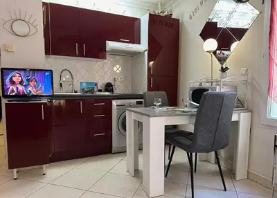 a kitchen with a table with chairs and a microwave at CANNES CENTRE 5 minutes de la mer in Cannes