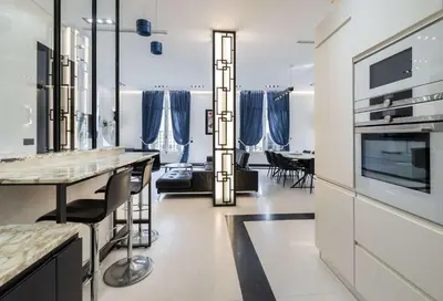 a kitchen and dining room with blue curtains at 110 m2 golden square, renovated, 20metres croisette, parking private in Cannes