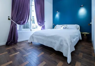 a bedroom with a bed with blue walls and purple curtains at 110 m2 golden square, renovated, 20metres croisette, parking private in Cannes