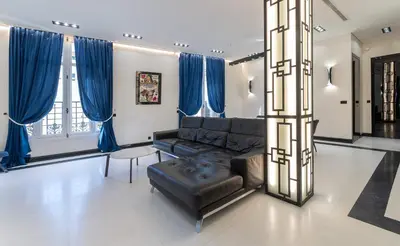 a living room with a black couch and blue curtains at 110 m2 golden square, renovated, 20metres croisette, parking private in Cannes