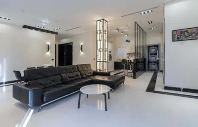 a living room with a black leather couch and a table at 110 m2 golden square, renovated, 20metres croisette, parking private in Cannes