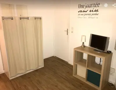 a room with a television and a tv stand with a monitor at Colorful Studio Cannes in Cannes