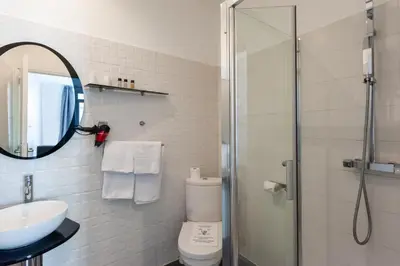 a bathroom with a shower and a toilet and a sink at Hotel l'Hotera in Cannes