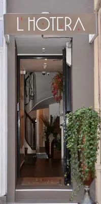 a store entrance with a sign for a hotel at Hotel l'Hotera in Cannes