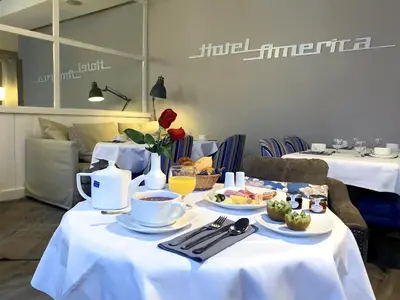 a table with plates of food and coffee on it at Hotel America in Cannes