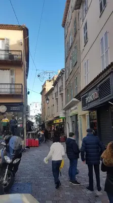 a group of people walking down a city street at Venizelos in Cannes