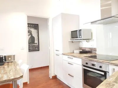 a kitchen with white cabinets and a table at Latour Sea Cannes in Cannes