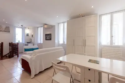 a living room with white cabinets and a table and chairs at Saint-Antoine Sea Cannes in Cannes