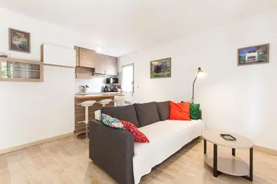 a living room with a couch and a kitchen at Fauvettes Sea Cannes in Cannes