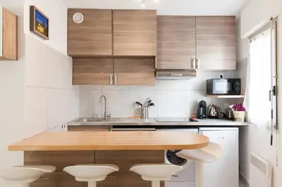 a kitchen with wooden cabinets and a wooden table at Fauvettes Sea Cannes in Cannes