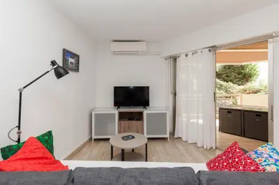 a living room with a couch and a tv at Fauvettes Sea Cannes in Cannes