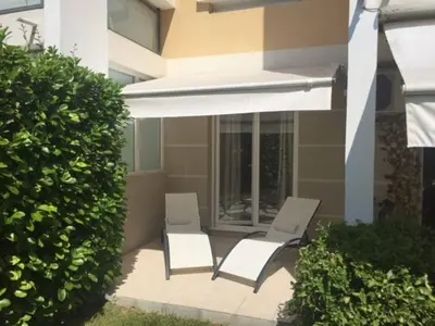 two white chairs on a patio in front of a building at Appartement les Eucalyptus Cannes in Cannes