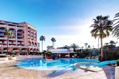 a large swimming pool in front of a hotel at Cannes apartment with sea view, aircondition and parking in Cannes