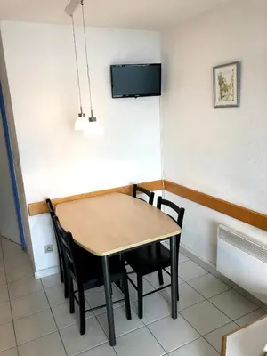 a dining room table with chairs and a tv on the wall at Cannes apartment with sea view, aircondition and parking in Cannes
