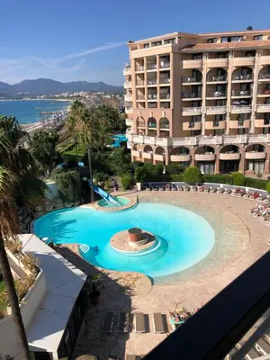 a large swimming pool in front of a building at Cannes apartment with sea view, aircondition and parking in Cannes