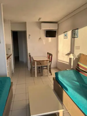 a living room with a table and a bed and a dining room at Cannes apartment with sea view, aircondition and parking in Cannes