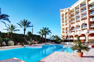 a swimming pool in front of a building at Cannes apartment with sea view, aircondition and parking in Cannes