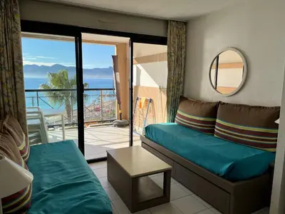 a living room with a couch and a balcony at Cannes apartment with sea view, aircondition and parking in Cannes