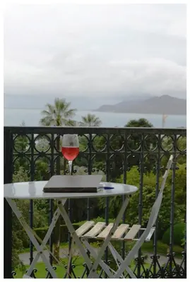 a glass of wine sitting on a table on a balcony at Appartement Claire Deluxe in Cannes