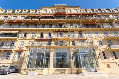 a large yellow building with windows and balconies at Appartement Claire Deluxe in Cannes