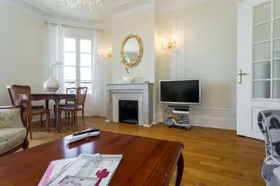 a living room with a fireplace and a tv at Appartement Claire Deluxe in Cannes