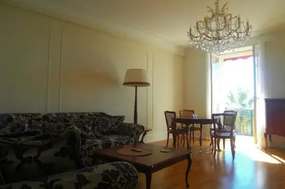 a living room with a couch and a table with chairs at Appartement Claire Deluxe in Cannes