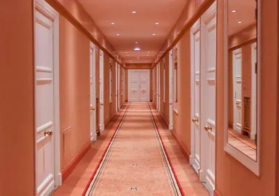 a hallway of a building with orange walls and a long aisle at Palais Miramar Imperial Croisette in Cannes