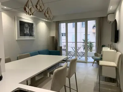 a living room with a dining room table and chairs at Two bedroom Fragonard Cannes in Cannes
